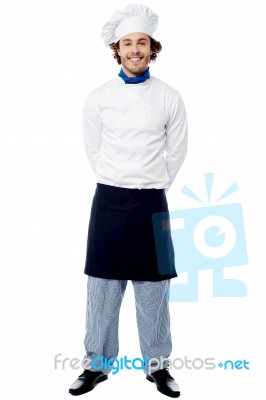 Young Chef Standing With Hands Behind Stock Photo