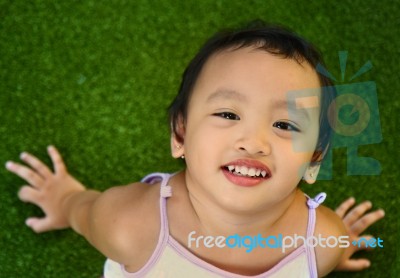 Young Child Sitting On Grass Stock Photo