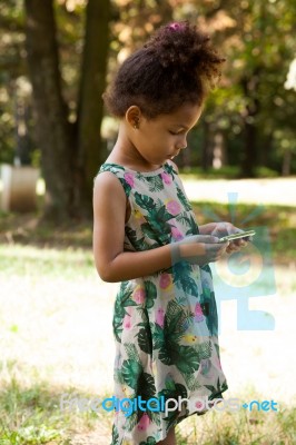 Young Child Using Smartphone At Park Stock Photo