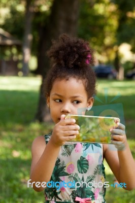 Young Child Using Smartphone At Park Stock Photo