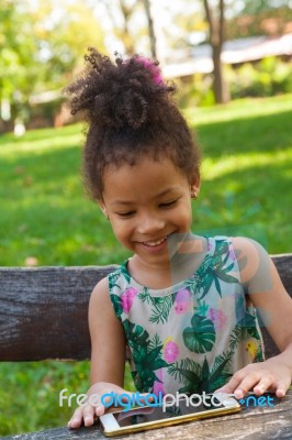 Young Child Using Smartphone At Park Stock Photo