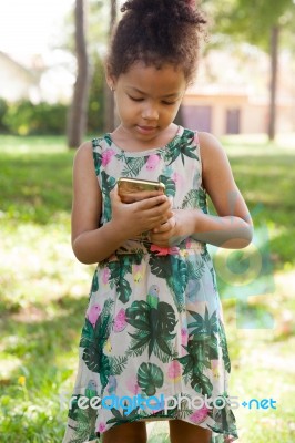 Young Child Using Smartphone At Park Stock Photo