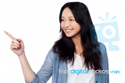 Young Chinese Girl Pointing And Looking Outside Stock Photo