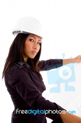 Young Constructor Holding Blue Prints And Looking At Camera Stock Photo