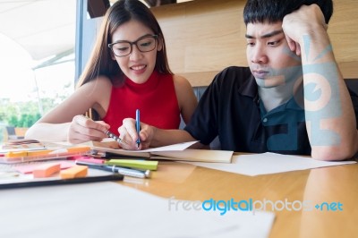 Young Couple Doing Coursework At The Table Stock Photo