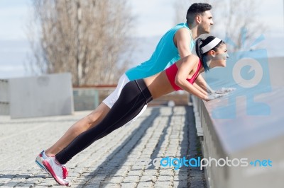 Young Couple Doing Push-ups Stock Photo