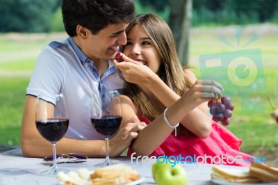 Young Couple Eating Grapes On Romantic Picnic In Countryside Stock Photo