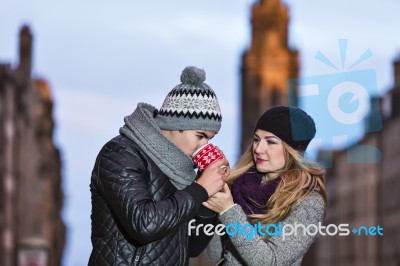 Young Couple In Love Embracing And Drinking Hot Drink From Red C… Stock Photo