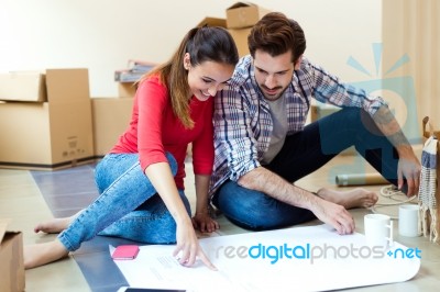 Young Couple Looking At The Blueprints Of Their New Home Stock Photo