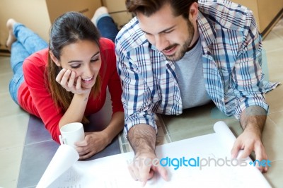 Young Couple Looking At The Blueprints Of Their New Home Stock Photo