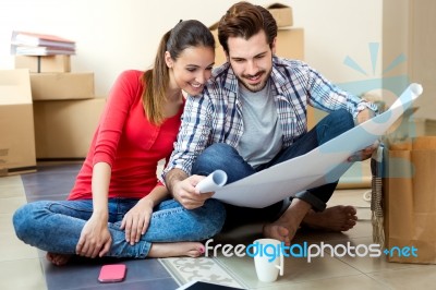 Young Couple Looking At The Blueprints Of Their New Home Stock Photo