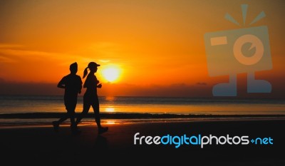 Young Couple: Man And Woman Run Together On A Sunset On Lake Coa… Stock Photo