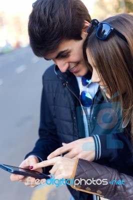 Young Couple Of Tourist In Town Using Mobile Phone Stock Photo