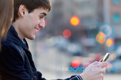 Young Couple Of Tourist In Town Using Mobile Phone Stock Photo