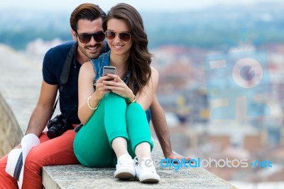 Young Couple Of Tourist In Town Using Mobile Phone Stock Photo