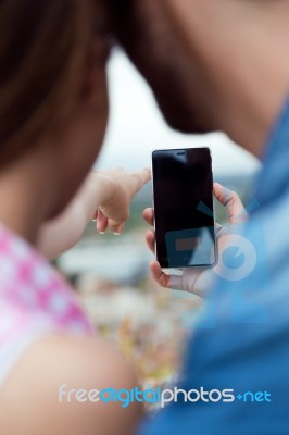 Young Couple Of Tourist In Town Using Mobile Phone Stock Photo