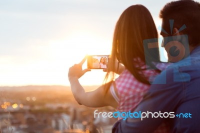 Young Couple Of Tourist In Town Using Mobile Phone Stock Photo