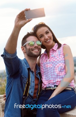 Young Couple Of Tourist In Town Using Mobile Phone Stock Photo