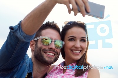 Young Couple Of Tourist In Town Using Mobile Phone Stock Photo