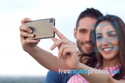 Young Couple Of Tourist In Town Using Mobile Phone Stock Photo