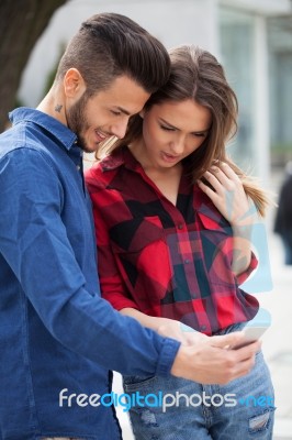 Young Couple Using Smart Phone Stock Photo