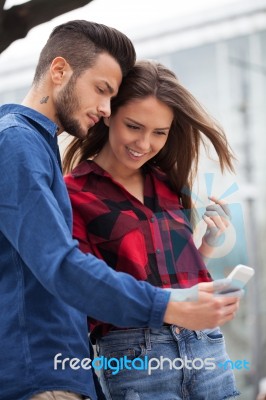 Young Couple Using Smart Phone Stock Photo