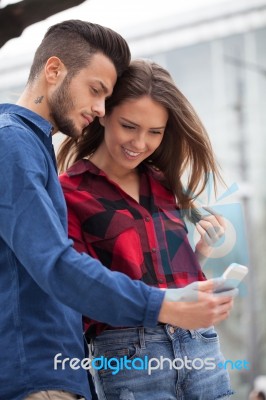 Young Couple Using Smart Phone Stock Photo