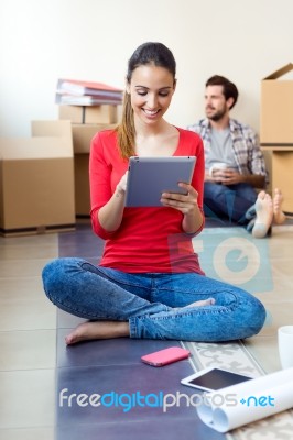 Young Couple With Digital Tablet Resting In Their New Home Stock Photo