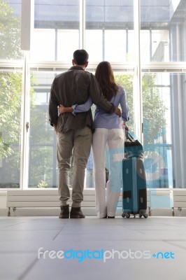 Young Couple With Luggage Waiting At Airport Stock Photo