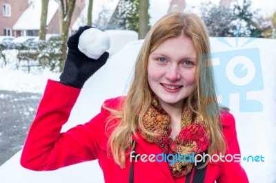 Young Dutch Woman Dressed In Red Holding Snowball Stock Photo