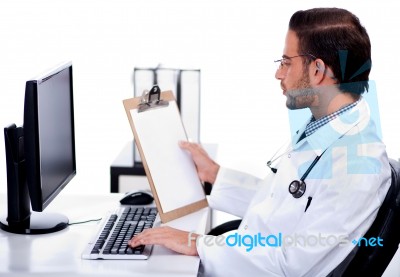 Young Ethnic Doctor Looking At Medical Report Deeply Stock Photo