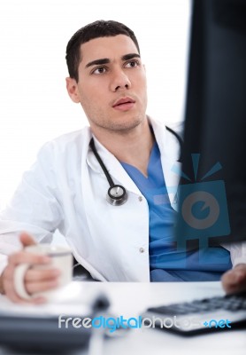 Young Ethnic Doctor Looking Deeply At The Computer Stock Photo