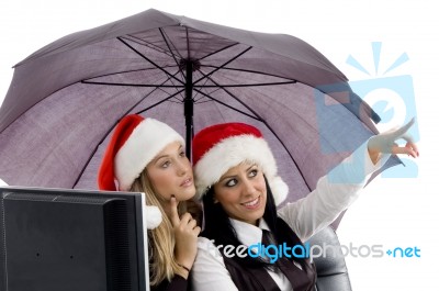 Young Executive Pointing Sideways And Wearing Red Christmas Hat Stock Photo