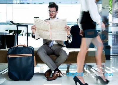 Young Executive Reading A Newspaper In The Hotel Reception Stock Photo