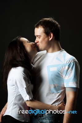 Young Family Kissng In Studio Stock Photo