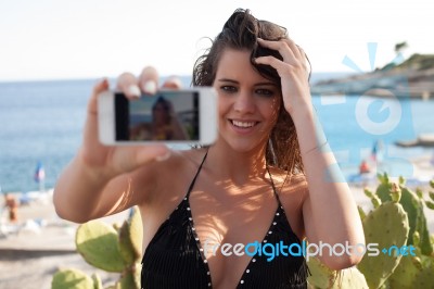 Young Female At The Seashore Taking Selfie Stock Photo