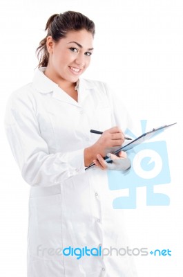 Young Female Doctor Writing On Notepad Stock Photo