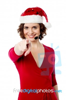 Young Female Santa Pointing Towards You Stock Photo