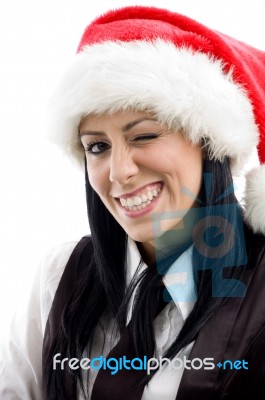 Young Female Winking Eyes And Wearing Christmas Hat Stock Photo