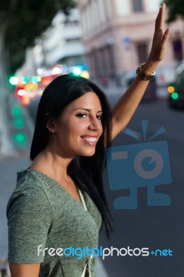 Young Girl Calling A Taxi In The City At Night Stock Photo