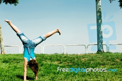 Young girl Doing cartwheel Stock Photo