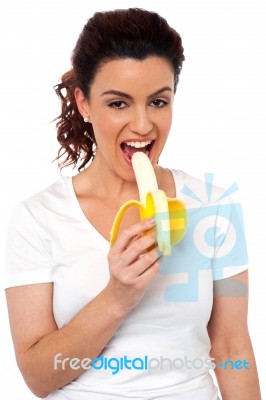 Young Girl Eating Banana Stock Photo