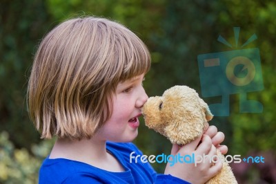 Young Girl Hugging Stuffed Dog Stock Photo