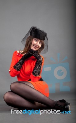 Young Girl In A Red Dress And A Black Hat Stock Photo