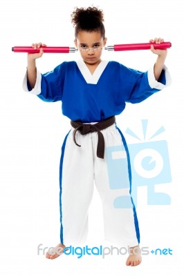 Young Girl In Karate Uniform Holding Nunchucks Stock Photo