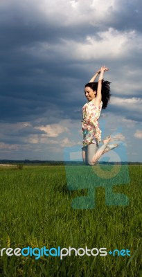 Young Girl Jumping On The Field Stock Photo