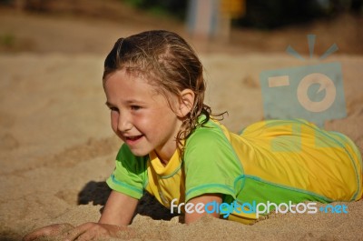 Young Girl Playing In The Sand Stock Photo