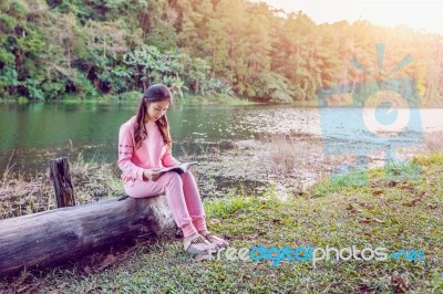 Young Girl Reading A Book In The Park Stock Photo