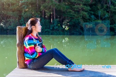 Young Girl Sitting On A Pier Stock Photo