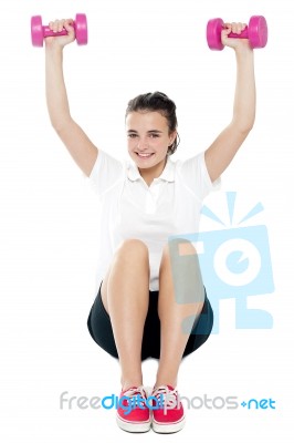 Young Girl Sitting On Floor And Doing Fitness Exercise Stock Photo